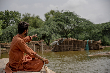 رجل ينظر بحسرة على قرية غمرتها المياه في باكستان.